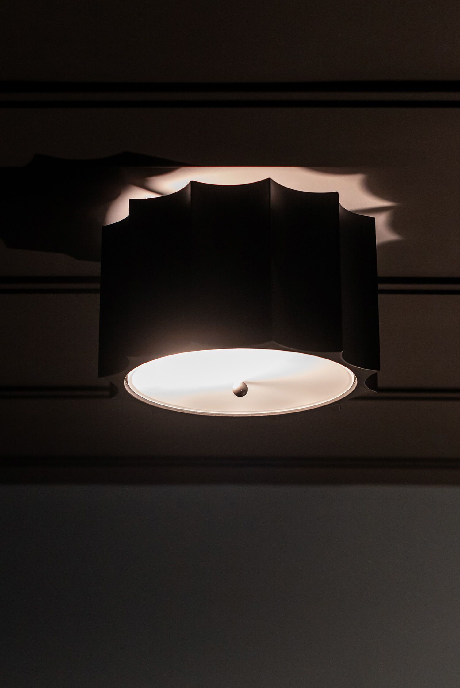 Marble island with bold veining, round multi-light chandelier, blue bar stools, and a glass wine room in the background