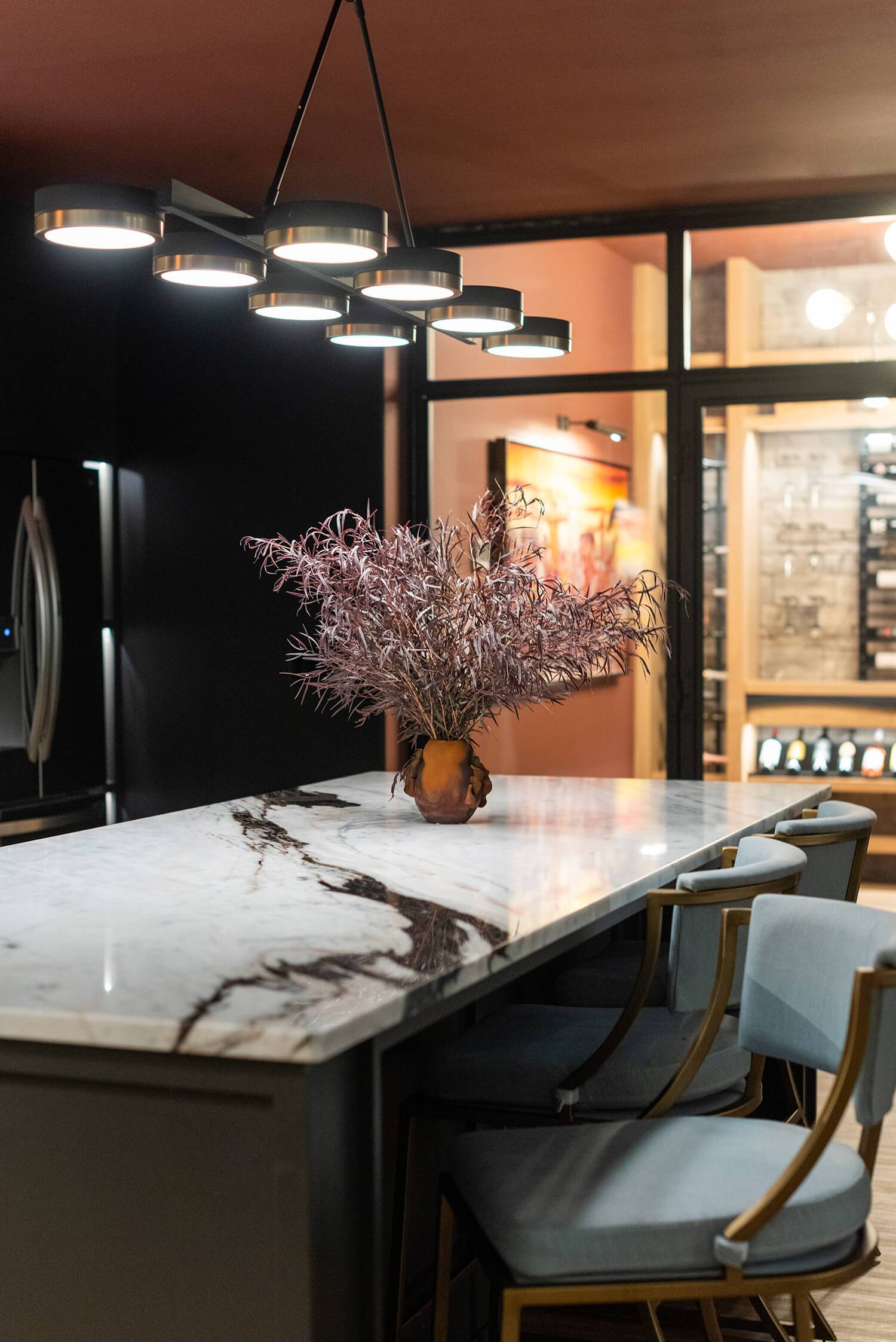 Stylish interior with dark walls, armchair, decorative plant, and framed artwork, featuring text about design services