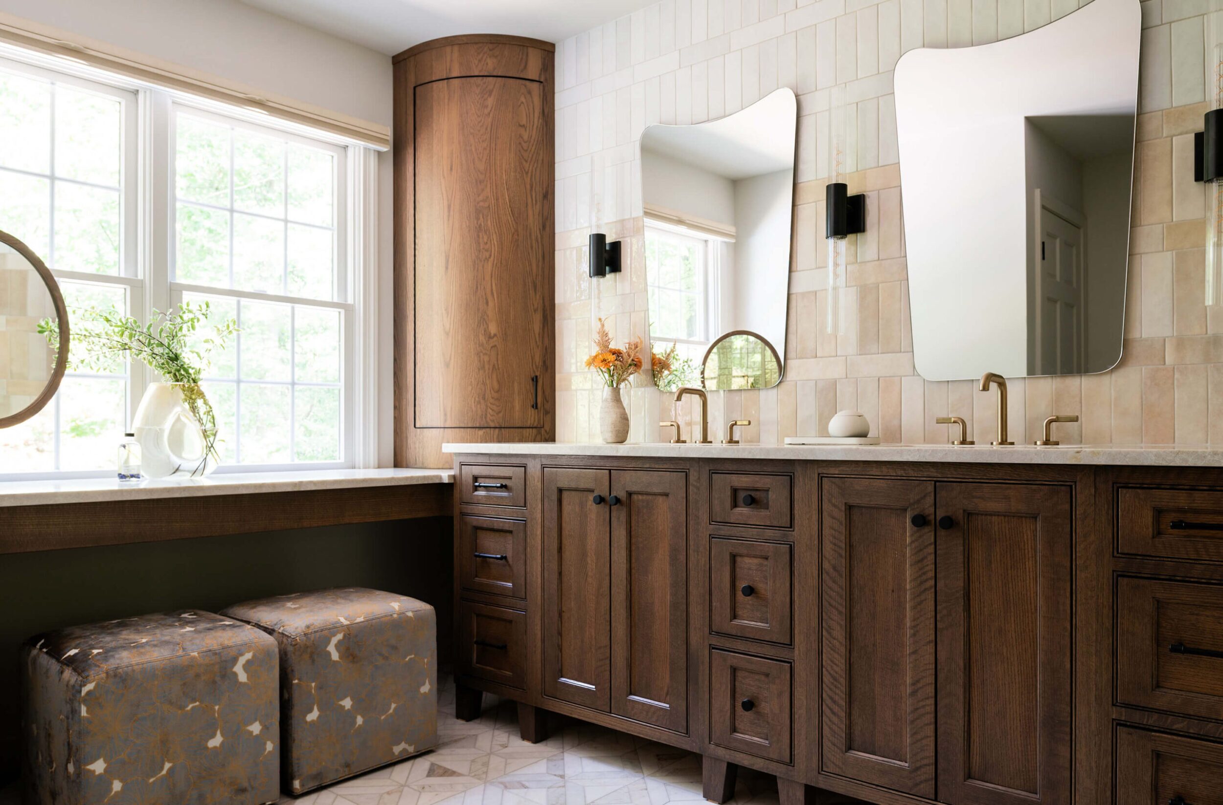 Modern bathroom with glass shower, patterned tile, and dark vanity with double sinks.