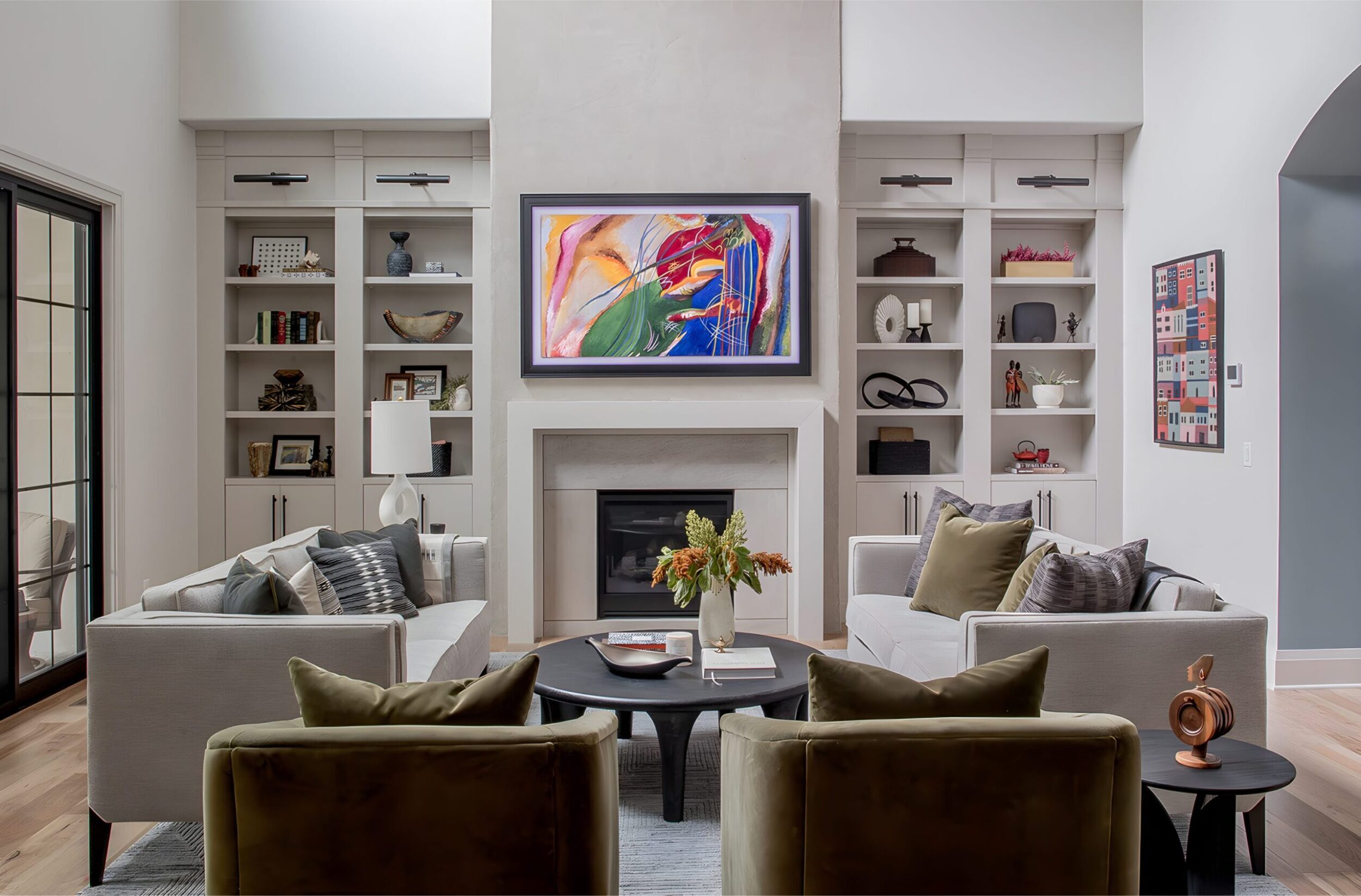 Contemporary living room with fireplace, built-in shelves, abstract framed art, and neutral modern seating