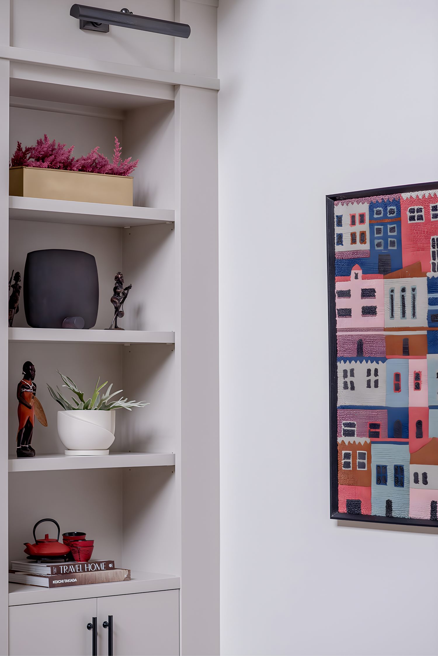 Built-in shelving with decor pieces beside colorful wall art