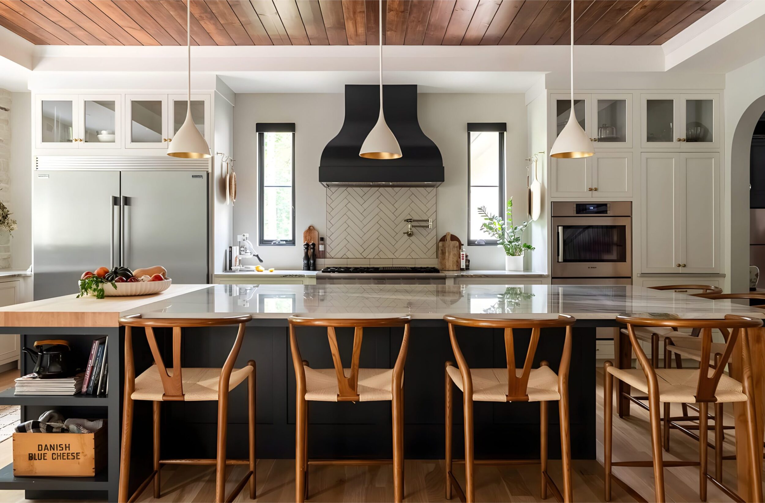 Modern kitchen with marble island, wood ceiling, pendant lights, and sleek cabinetry with natural light accents.