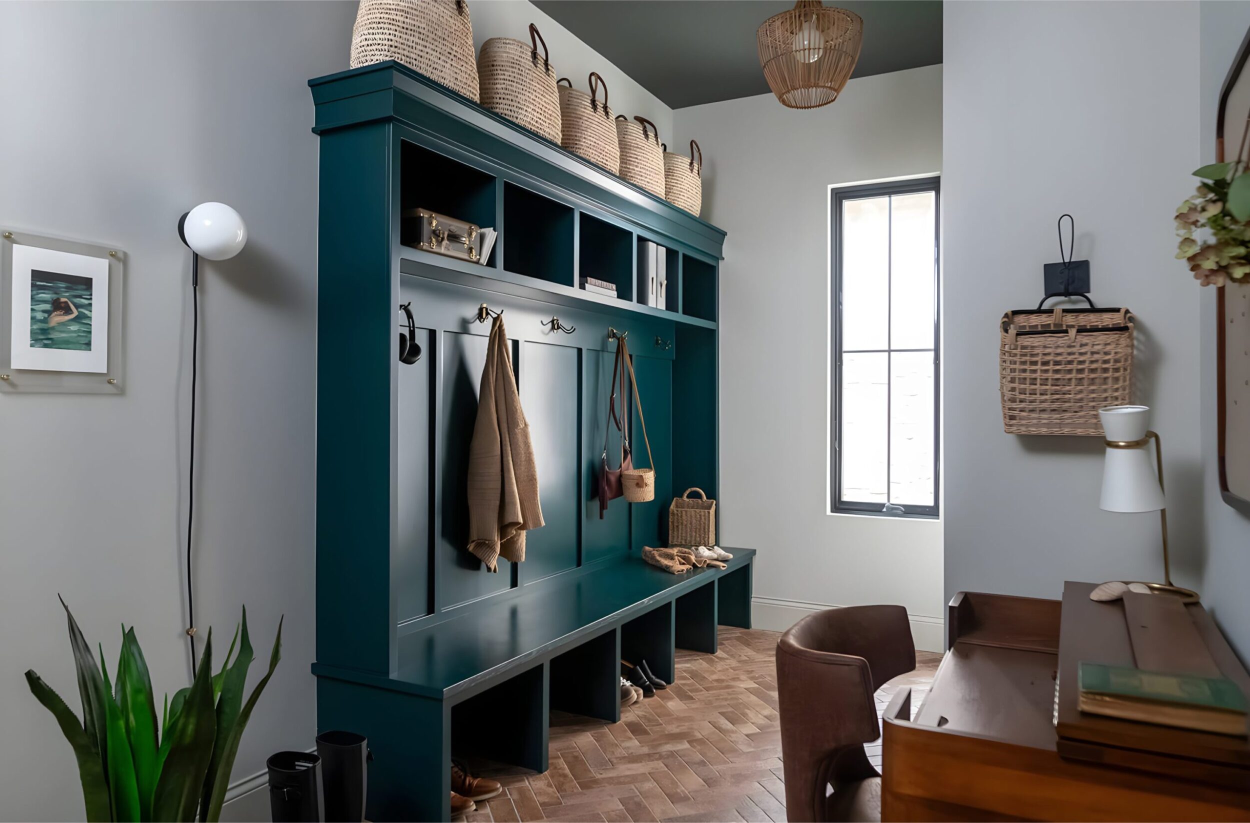Mudroom with teal built-in storage, woven baskets, hanging coats, and natural light from tall window.
