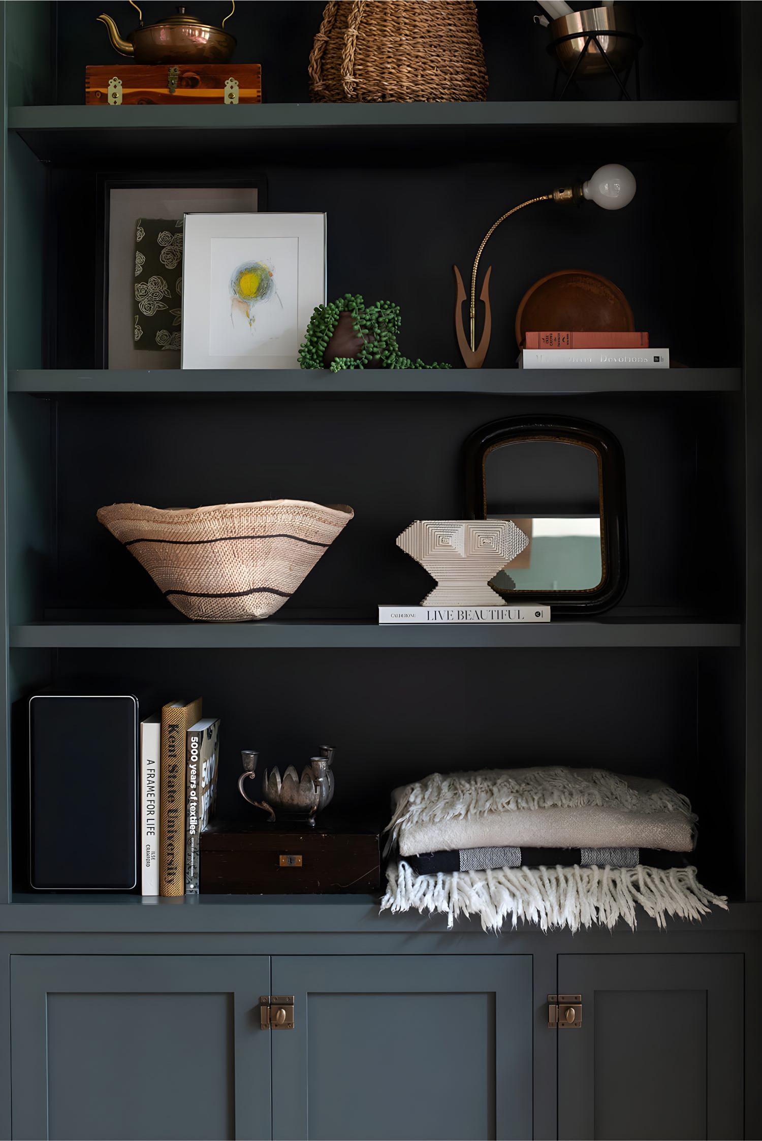 Built-in shelving styled with art, books, baskets, and textured accents, creating a layered and curated look.