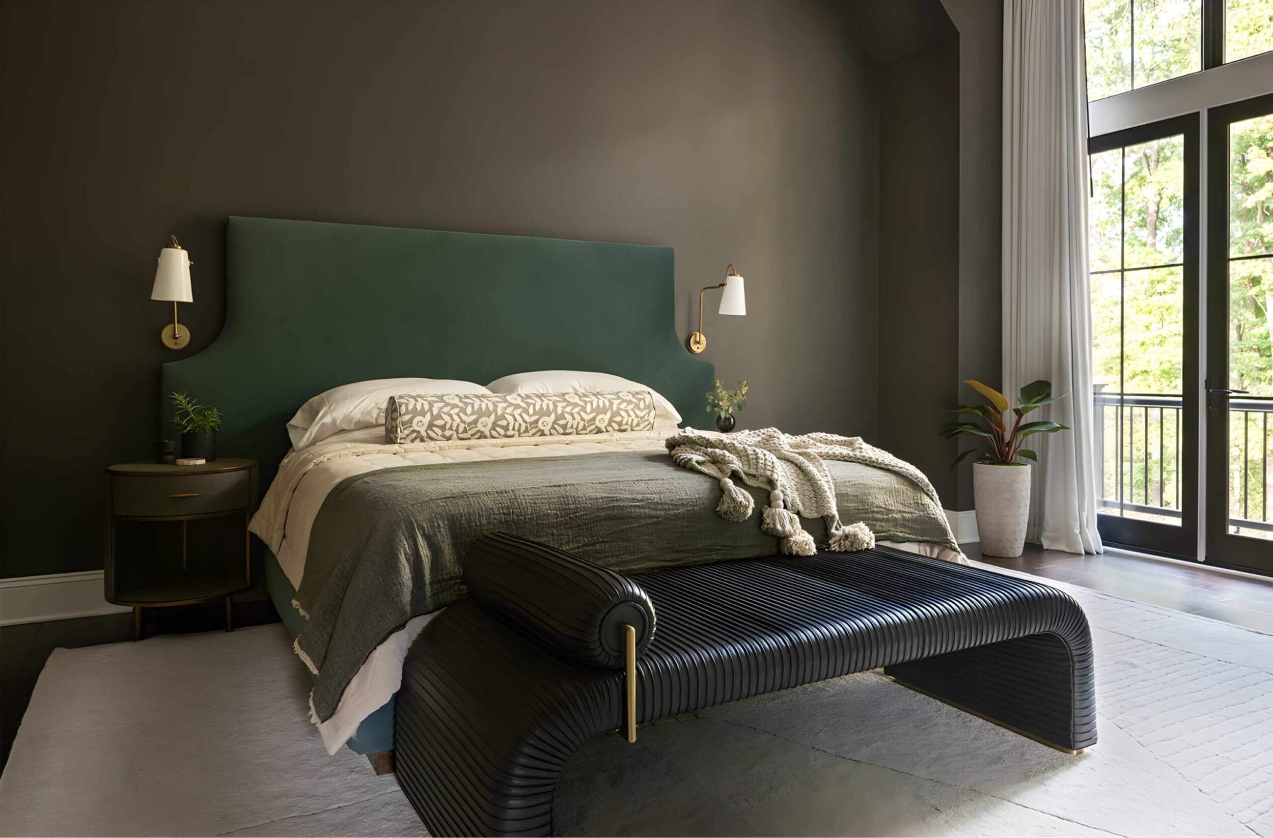 Bedroom with dark walls, green upholstered headboard, white bedding, black bench, and large window with curtains