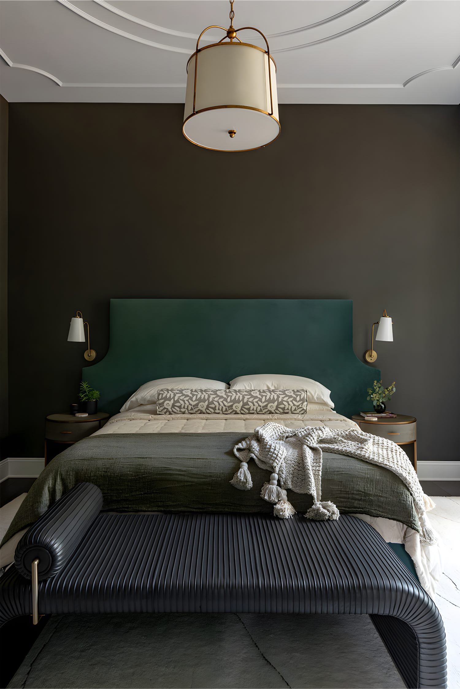 Bedroom with dark walls, teal headboard, pendant light, black bench, and layered neutral bedding with throw blanket