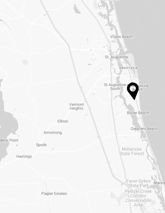 Black and white map of the St. Augustine, Florida area, highlighting the coastline and nearby towns such as Butler Beach, Crescent Beach, Elkton, and Hastings. A location pin is placed near St. Augustine Beach along the Atlantic shoreline.