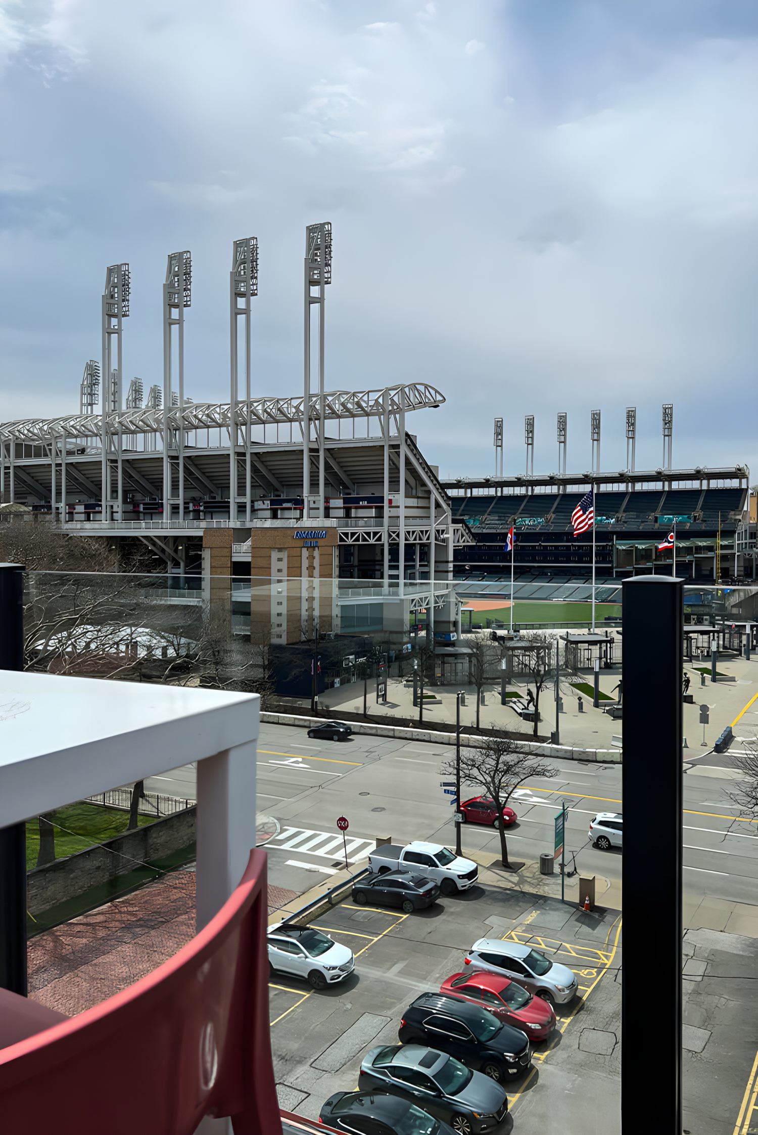 View of Progressive Field baseball stadium with flags and street-level parking from rooftop patio.