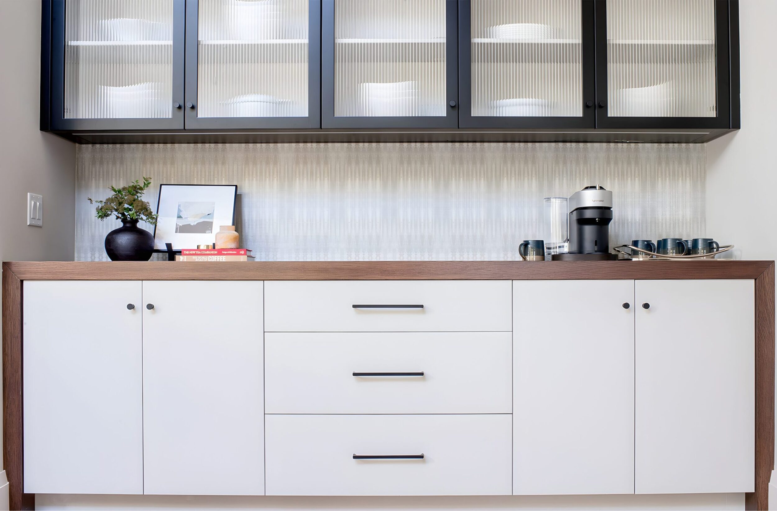 White sideboard with black framed cabinets and coffee station setup