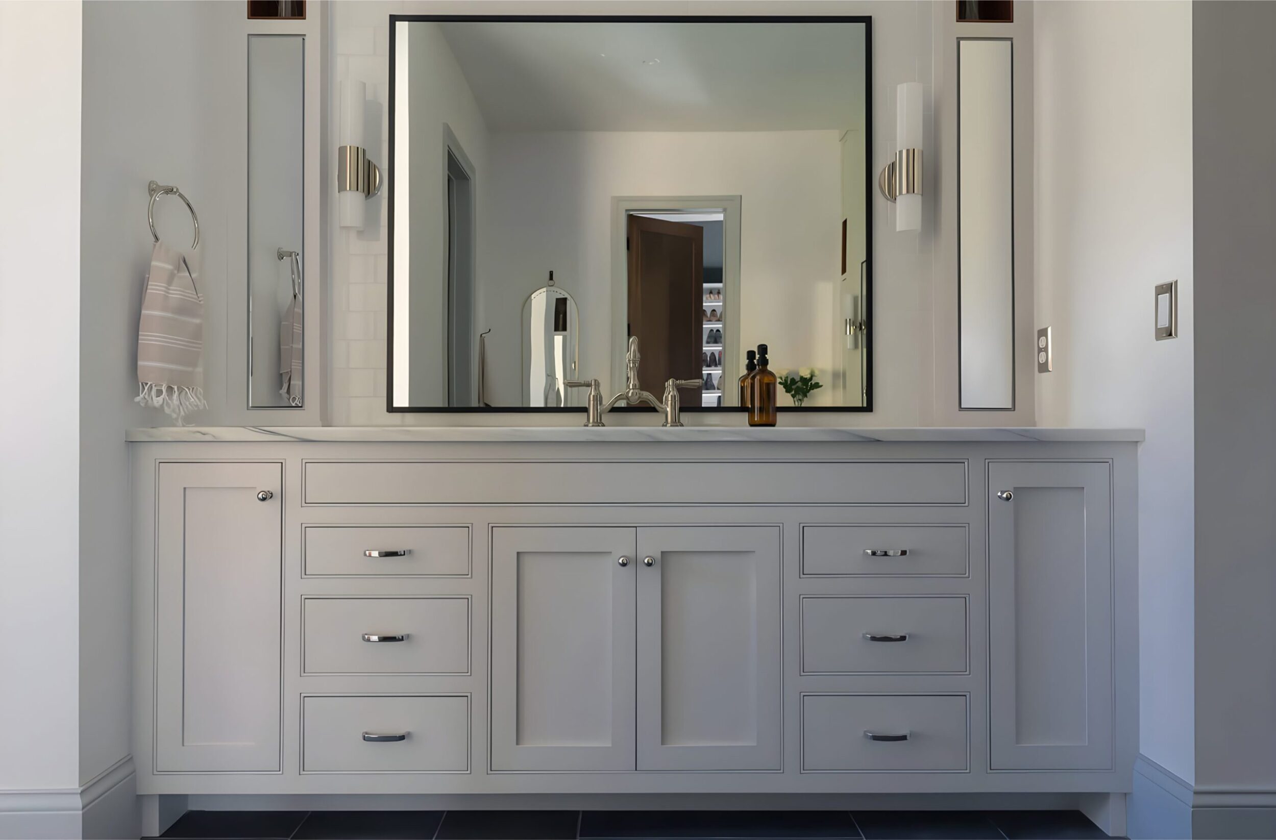 Glass shower with herringbone tile ceiling detail, gray tiles, and natural light creating a sleek spa-inspired atmosphere.