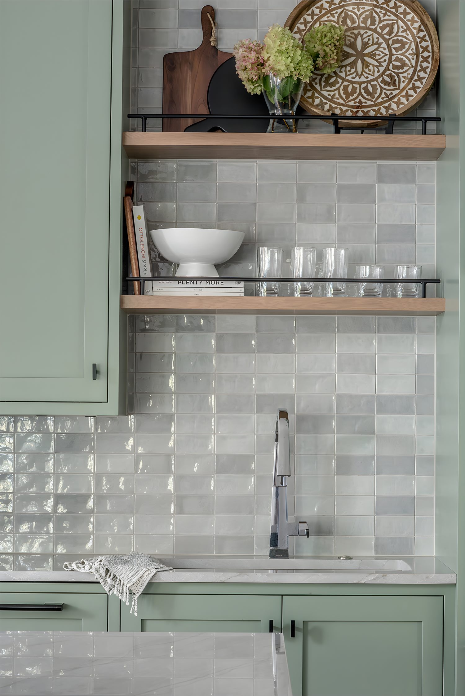 Kitchen shelving with decorative plates, glassware, and flower arrangement