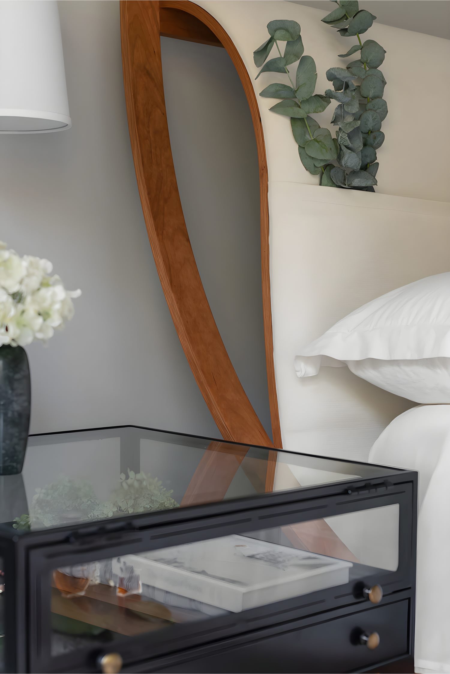 Cozy master bedroom with neutral bedding, wood accents, and large windows overlooking a serene wooded landscape.