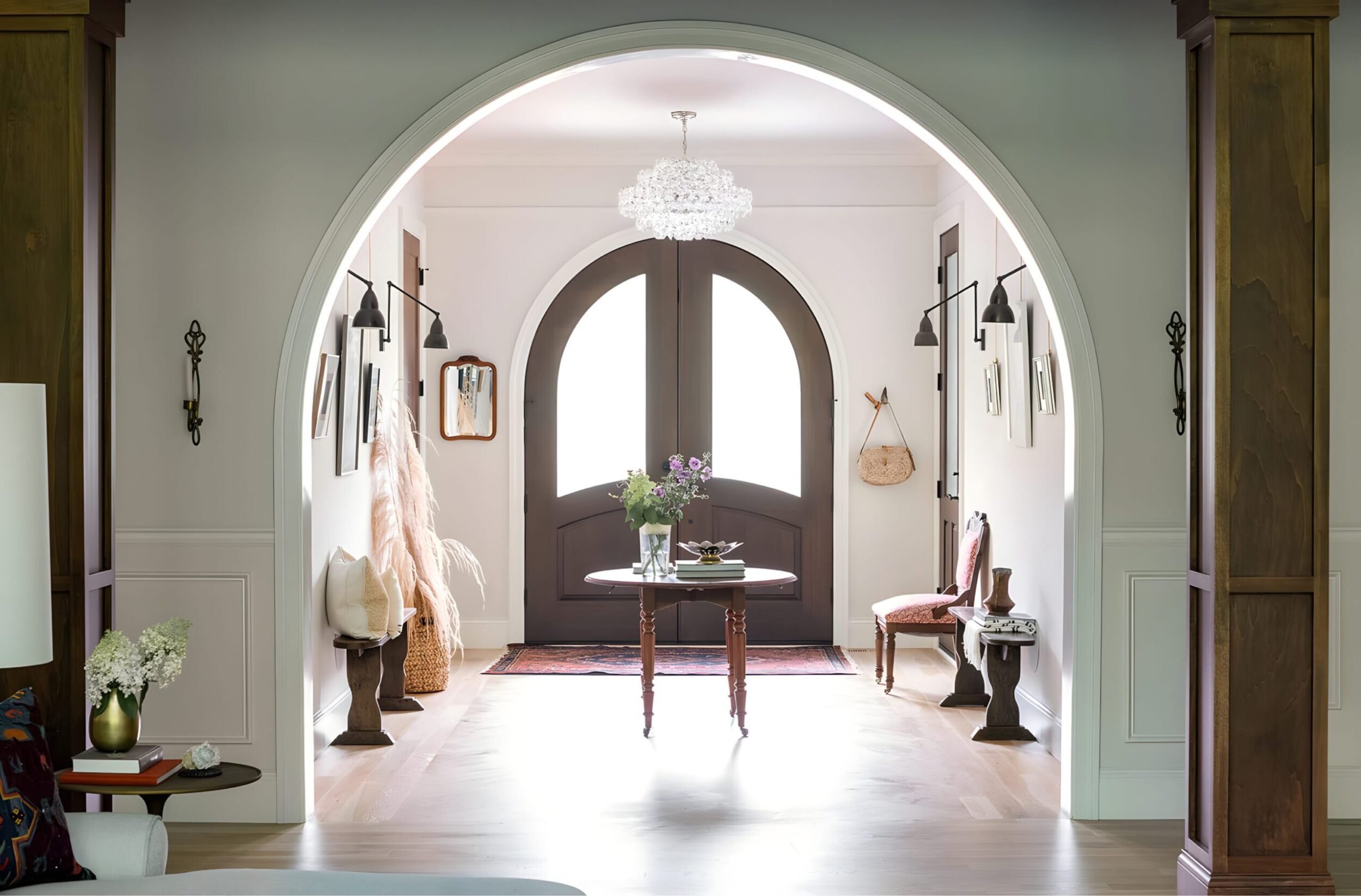 Entryway with grand arched double doors, chandelier, and styled console table creating an elegant welcoming space.