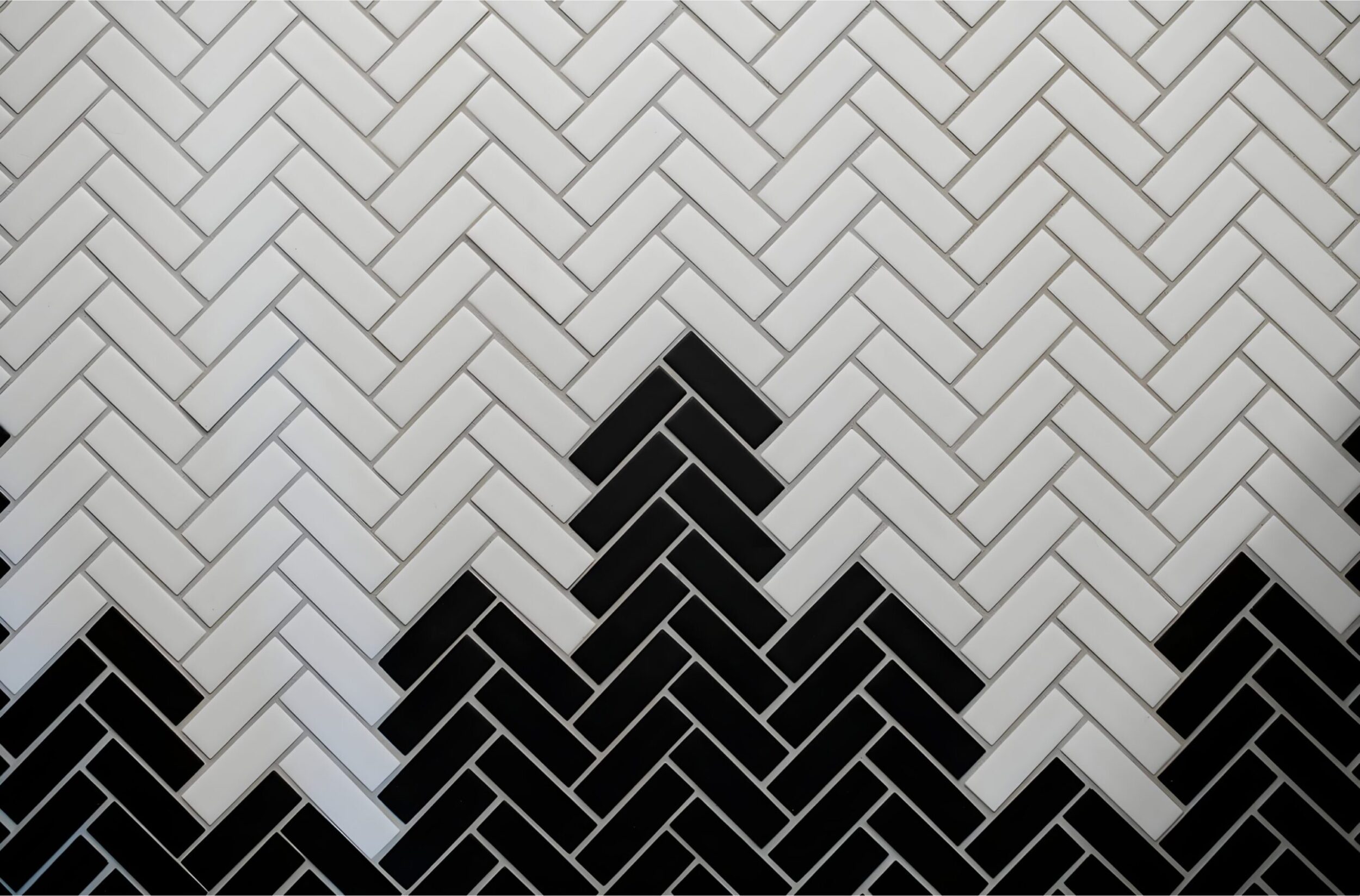 Black and white herringbone tile backsplash with bold geometric pattern creating contrast and modern style.