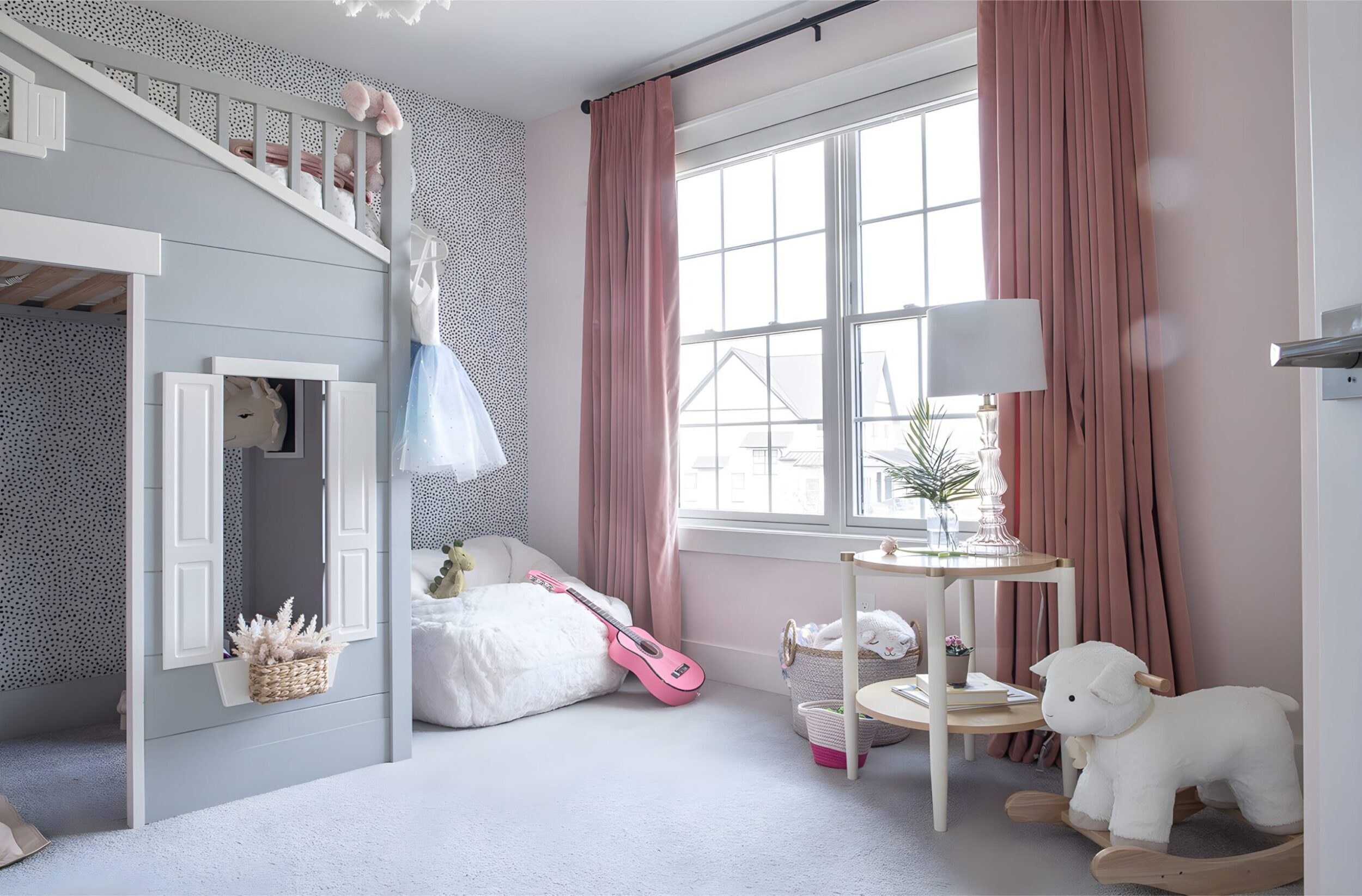Girls’ bedroom with white bed, striped bedding, floral garland on wall, and colorful framed kids’ artwork