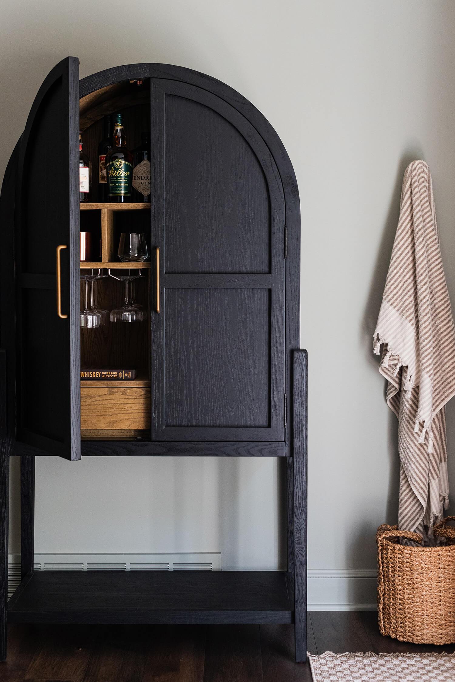 Bright living room with sage cabinetry, modern decor, fireplace, and round velvet chairs in a symmetrical arrangement.